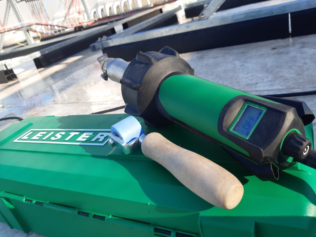 Leister ručná zváračka na hydroizoláciu PVC strechy s pozadím plochej strechy